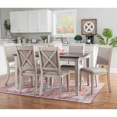 a dining room table and chairs with a rug on the floor