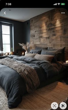 a large bed sitting in a bedroom next to a window with candles on top of it