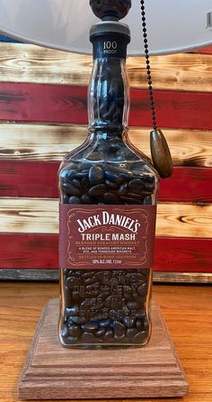 jack daniels triple mash bottle sitting on a wooden stand with an american flag in the background