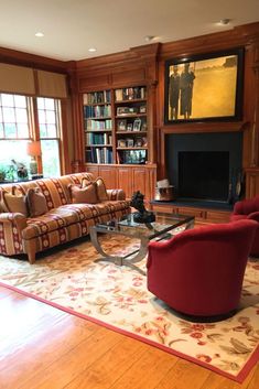 a living room with couches, chairs and a fire place in the middle of it