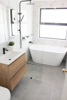 a bathroom with a sink, toilet and bathtub next to a window in it