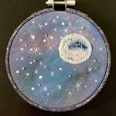 a blue and white round object with stars on it's side, sitting on a black surface