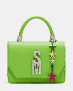 The BRAT mini bag features a top handle and a multi-colored star charm with bubble letter logo letters for a trendy look. With a crossbody strap and interior back wall, it offers convenience and organization while making a stylish statement. Structured mini top-handle bag Multi-colored star charm Rhinestone bubble logo letters Detachable crossbody strap Top handle: 3 inches Crossbody strap: 24 inches 5in H x 7in W x 3in D Synthetic materials Duster bag included Imported Trendy Top Handle Shoulder Bag With Logo, Green Top Handle Shoulder Bag With Logo, Bubble Logo, Logo Letters, Bubble Letter, Mini Top, Bubble Letters, Synthetic Materials, Strap Top