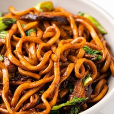 a close up of a bowl of food with noodles and broccoli in it