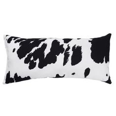 a black and white cow print pillow on a white background