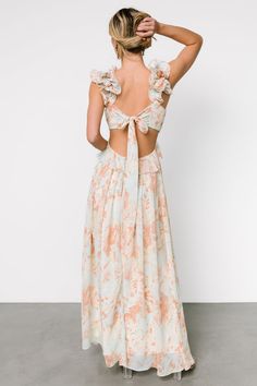 the back of a woman wearing an orange and white floral print dress