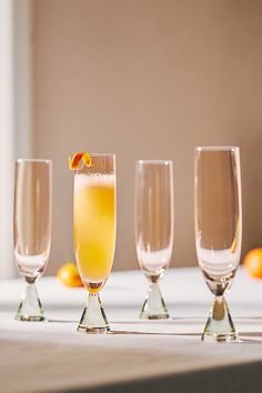 four glasses filled with different types of drinks sitting on a table next to each other