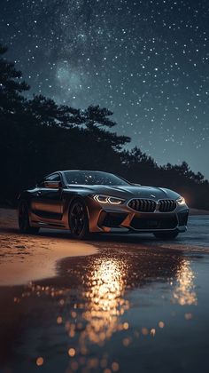 a bmw concept car parked on the beach at night with stars in the sky above