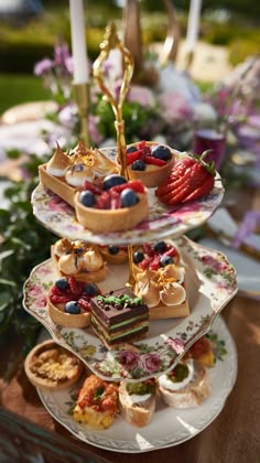 three tiered trays filled with cakes and pastries on top of each other