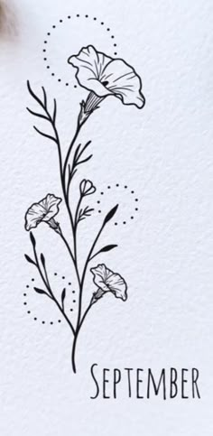 a white card with black ink on it and some flowers in the middle that says, september