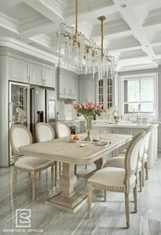 a dining room table surrounded by chairs and a chandelier in the middle of a kitchen