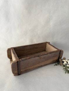 an old wooden box with flowers in it on a white cloth covered tablecloth background