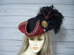 Beautiful ladies black woolen pirate hat with burgundy wine venise lace surrounding the brim of the hat with golden glass rhinestones at each point of the lace with matching braid. Black ostrich feathers with a touch of dark burgundy feathers, black cocarde with large sparkly jewel. This hat is 22.5" for the inside circumference with a built-in hat sizer. Just cinch and tie. Please measure your head as I cannot make the circumference bigger so, please keep that in mind. This is not an oversized Adjustable Pirate Hat For Costume, Adjustable Pirate Hat For Costumes, Pirate-style Brimmed Hat For Costume Party, Pirate Style Brimmed Hat For Costume Party, Pirate Style Brimmed Costume Hat For Parties, Pirate Hat With Curved Brim For Costume, Pirate-style Brimmed Costume Hat, Fair Outfits, Pirate Hats