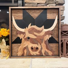 a wood carving of a bull's head is displayed in front of a brick wall