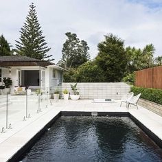 an outdoor swimming pool in front of a house