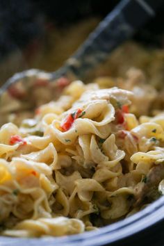 a close up view of some pasta with chicken and peppers on it, in a bowl