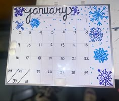 a calendar with blue snowflakes and the word january written on it in black ink