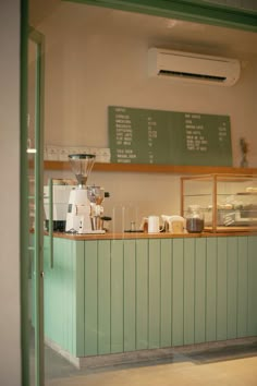 a coffee shop with green walls and counters