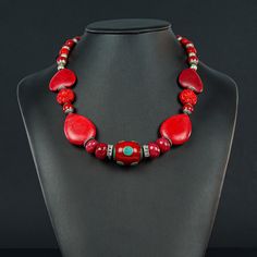 This unusual red Necklace is 20 1/4" long made with a Tibetan oval centerpiece of Enamel and Turquoise (30x20mm) framed with 4 faceted red Jade rondels, red  Howlite ovals and hearts and Tibetan red , silver ended 9mm decorative beads to frame the Sterling lobster clasp (10x20mm) Traditional Red Necklace With Natural Stones, Oval Beads Red Coral Jewelry Gift, Red Coral Oval Bead Jewelry As Gift, Red Costume Jewelry For Valentine's Day, Red Oval Beads Jewelry For Gift, Handmade Oval Beads Red Coral Jewelry, Elegant Handmade Red Beads, Gems, And Cabochons, Handmade Red Coral Oval Beads Jewelry, Handmade Red Coral Jewelry With Oval Beads