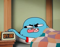 an alarm clock sitting on top of a table next to a cartoon character in bed