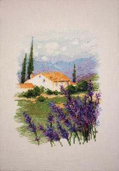 a cross stitch picture with purple flowers in the foreground and a white house in the background