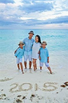 a family standing on the beach in front of the number 20 written in the sand