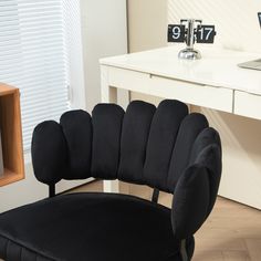 a black chair sitting in front of a white desk