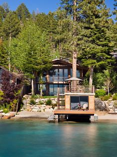 a house sitting on top of a lake surrounded by trees