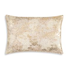 a gold and white pillow on a white background