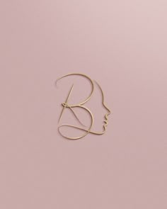 a woman's face is shown with the letter b in gold on a pink background