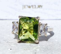 Don't miss this opportunity to own this beautiful gemstone ring crafted in 14k gold filled => Gemstone Type - Peridot, Clear Quartz => Gemstone Cut - Faceted => Gemstone Size - 8*10 mm, 3*5 mm => Total Number of Gemstones - 3 => Metal Type - 14k Gold Filled (Tarnish Resistant And Nickel Free) - also available in 925 sterling silver * Please contact me for pricing on a sizes larger than 11 * ~ Feel free to ask me about custom made designs. ❏ Replacements and custom orders : ✪ 925 sterling silver Green Rectangular Stone Ring, Rectangular 14k Gold Jewelry With Accent Stones, Gold Jewelry With Square Cut Accent Stones, Square Cut Gold Jewelry With Accent Stones, Green Square Cut Ring With Center Stone, Green Square Cut Rings With Accent Stones, Green Square Cut Stone Jewelry, Rectangular Yellow Gold Jewelry With Accent Stones, 14k Gold Green Rectangular Ring