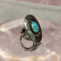 Embrace the timeless allure of vintage elegance with this exquisite Vintage Sterling Silver Ring featuring a vibrant turquoise stone. This unique piece of fine jewelry boasts a rich dark patina on sterling silver, adding to its unique and antique appeal. Perfect for those who appreciate the beauty of turquoise and the craftsmanship of vintage jewelry. Details: Material: Sterling Silver Gemstone: Turquoise Ring Size: 6.5 Condition: Good Vintage Condition Patina: Dark, enhancing the vintage appeal Style: Classic, Elegant, Unique This beautiful ring showcases a striking turquoise stone, set in a sterling silver band with a lovely dark patina. The combination of the vibrant turquoise and the darkened silver creates a captivating contrast that is both eye-catching and sophisticated. Why You'll Elegant Turquoise Ring Collectible, Southwestern Style Ring With Patina, Heirloom Turquoise Gemstone Ring For Collectors, Adjustable Southwestern Style Ring With Patina, Heirloom Style Turquoise Ring Collectible, Heirloom Turquoise Ring Collectible, Turquoise Ring With Patina For Anniversary, Oval Turquoise Ring With Patina, Heirloom Turquoise Gemstone Ring Collectible