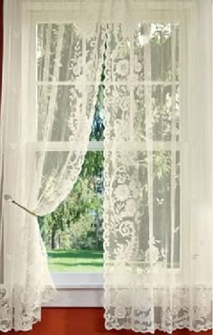 an open window with white lace curtains and red walls