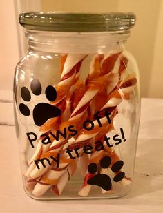 a glass jar filled with dog treats on top of a table