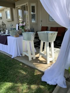 an outside area with tables and chairs covered in white draping on the grass