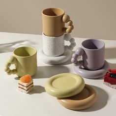 there are many different cups and plates on the table