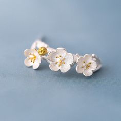 Add a touch of flower power to your look with these adorable hoops! Made with 925 sterling silver, these dainty and delicate earrings feature a charming mix of cherry blossom, plum blossom, and peach blossom designs. At 18mm x 7mm, they're the cutest addition to any outfit! Delicate Spring Jewelry With 3d Flowers, Spring Flower Shaped Jewelry With 3d Flowers, Blossom Flower Jewelry With 3d Flowers, Blossom Color Jewelry With 3d Flowers, Blossom Flower Jewelry For Spring, Spring Flower Jewelry With 3d Flowers, Delicate Jewelry For Anniversary In Spring, Delicate Jewelry For Spring Anniversary, Delicate Spring Jewelry For Anniversary