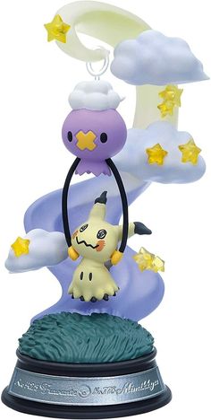 a small figurine is sitting on top of a base with stars and clouds