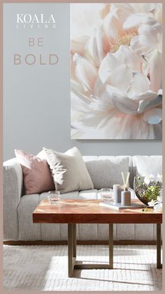 a living room scene with focus on the coffee table and large floral painting above it