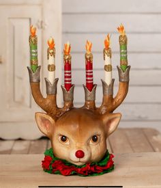 a deer head with candles in it's antlers