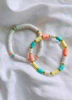 two bracelets are sitting on a white sheet