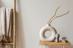 a white vase sitting on top of a wooden table next to a towel and other items