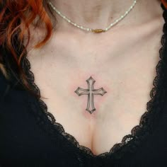 a woman with a cross tattoo on her chest