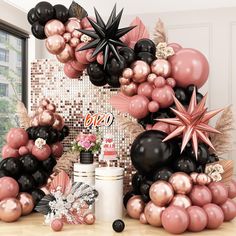 the balloon arch is decorated with black, pink and gold balloons