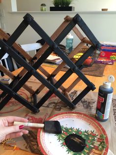 a person is painting a plate on the table with paintbrushes and other items