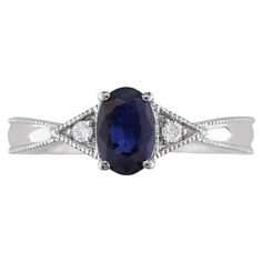 an oval shaped blue sapphire and diamond ring on a white gold band with diamonds around the band