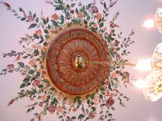 the ceiling is decorated with colorful flowers and leaves in an ornate pattern on it's surface