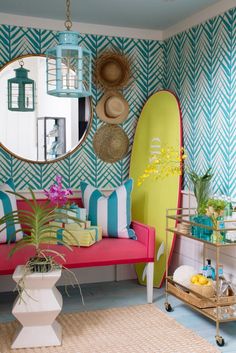 a living room filled with furniture and a surfboard on the wall next to a mirror