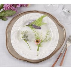 a white plate topped with flowers and greenery