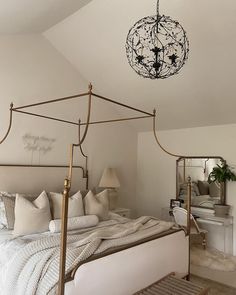 a bedroom with a bed, chandelier and pillows on the bottom half of it